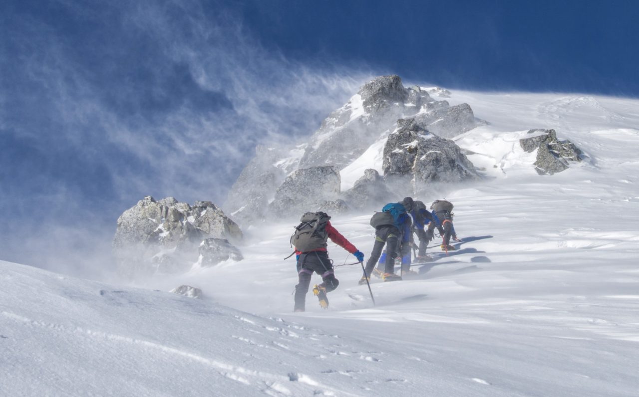 Mountain climbers reaching the summit like sales teams successfully closing a deal